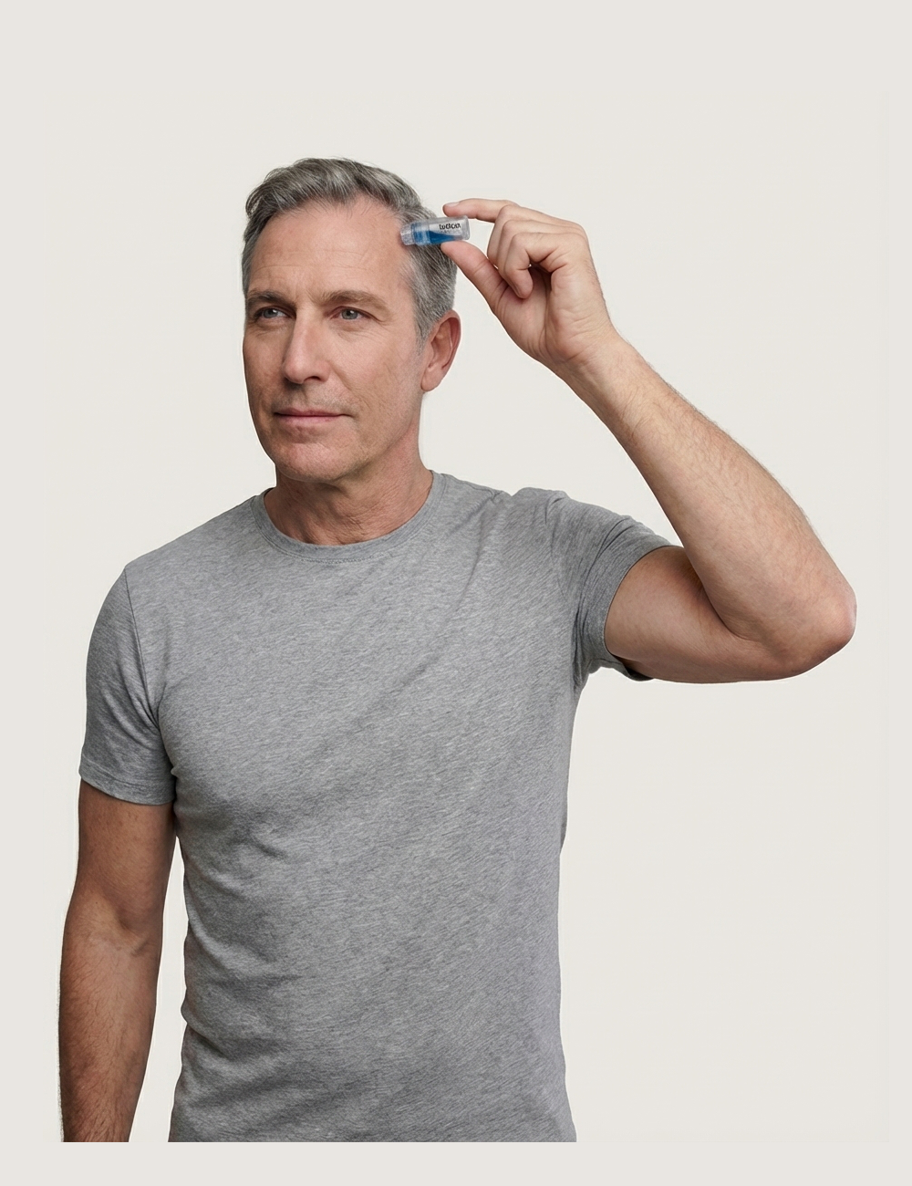 Distinguished man applying the Follicle & Co. Micro-Infusion System to his front hairline